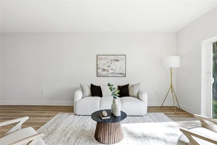 Bright living area with sliding doors, modern flooring, and space for comfortable seating.