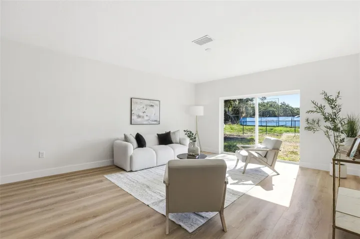 Living room with sliding glass doors overlooking the backyard and open rear setting.