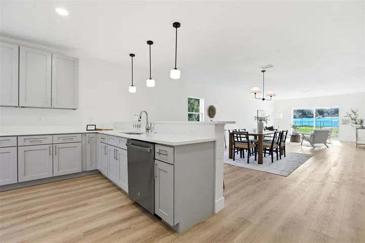 New construction kitchen with granite countertops, center island, pendant lighting, and modern cabinetry.