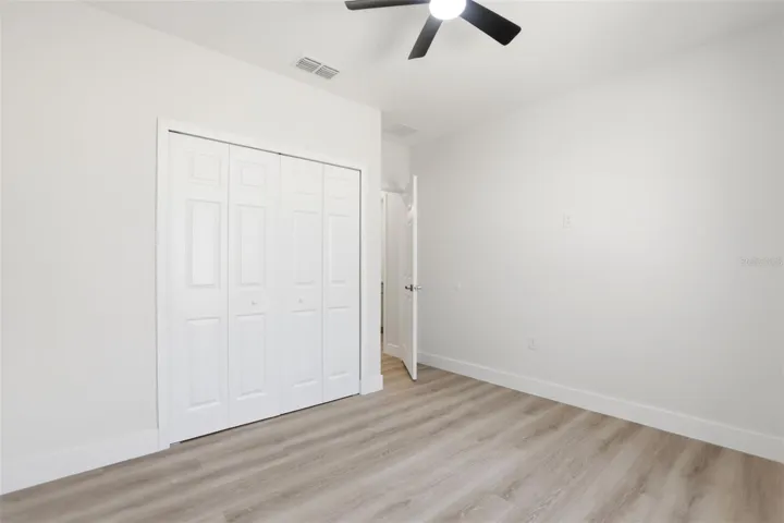 Secondary bedroom with closet, ceiling fan, and move-in-ready finishes.