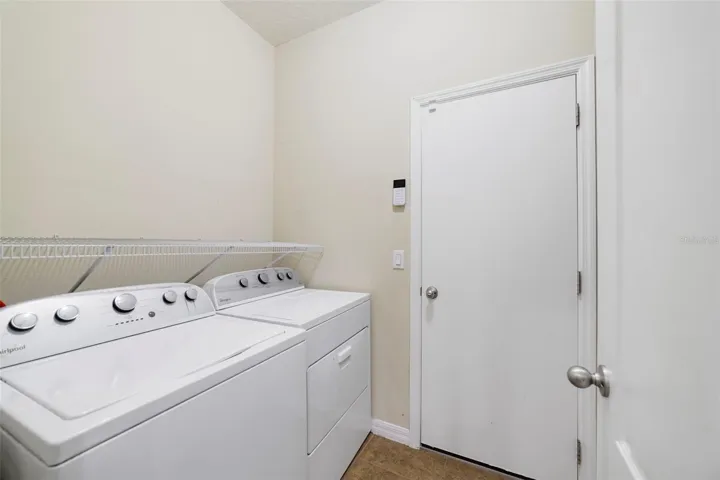 Just off the Kitchen, the convenient Laundry Room includes the washer, dryer and a shelf to store supplies.