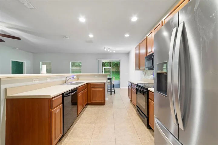 The Kitchen is thoughtfully designed with an abundance of cabinetry and counter space, a stylish tile backsplash, BREAKFAST BAR, and a convenient closet pantry.