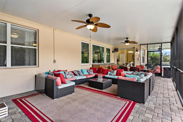 Expansive Screened Enclosed Lanai with brick pavers helps continue the outdoor living and entertaining space.