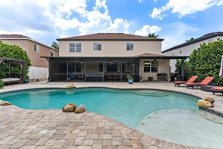The home SHOW STOPPER-swimming pool with rock water fall, brick paver decking, private cabana, shrubs for privacy, and more.