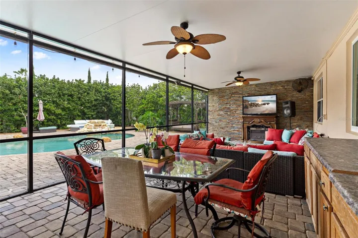 Expansive Screened Enclosed Lanai with brick pavers helps continue the outdoor living and entertaining space.