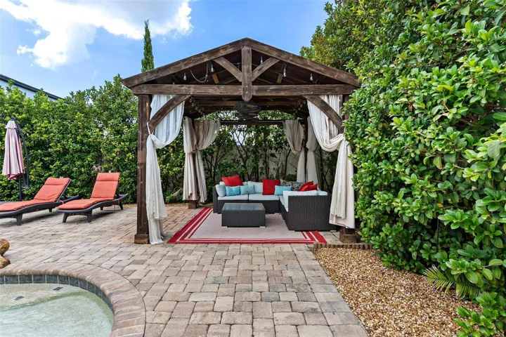 The home SHOW STOPPER-swimming pool with rock water fall, brick paver decking, private cabana, shrubs for privacy, and more.