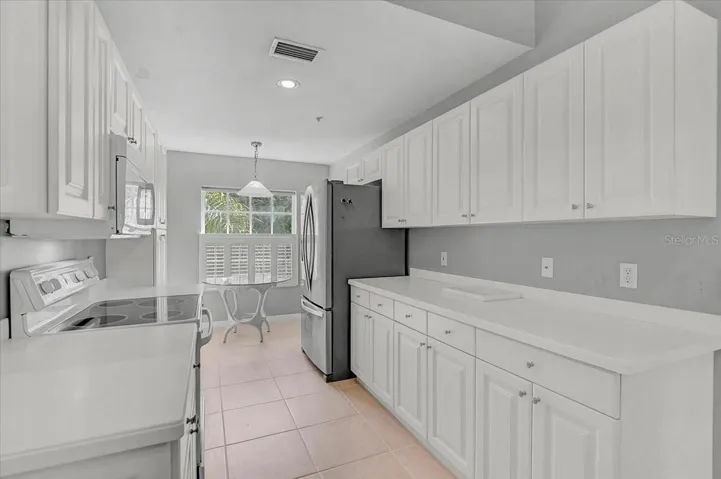 Kitchen with lots of storage and dining area with plantation shutters