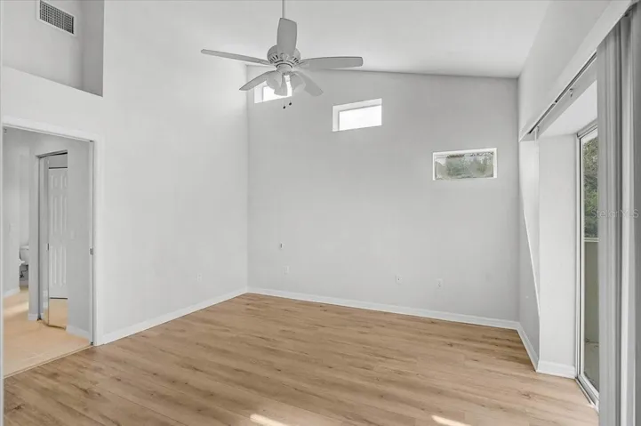 Master bedroom with soaring ceiling and slider to lanai