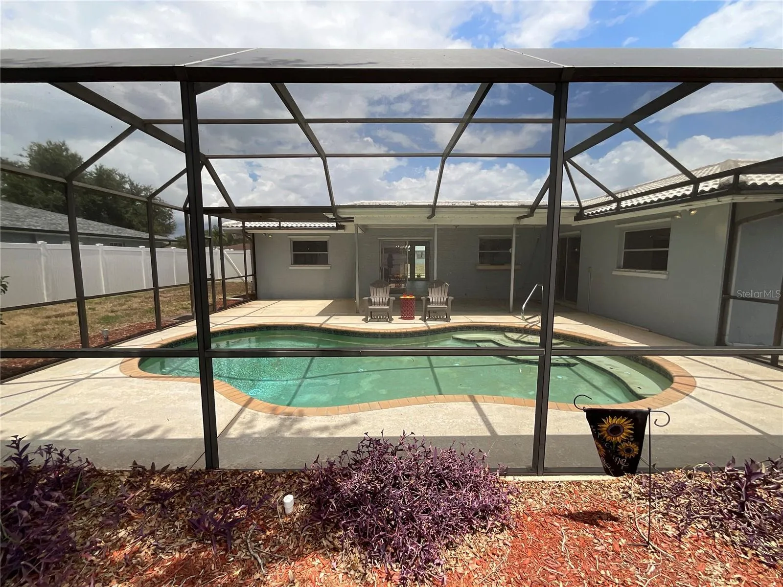 Quaint garden area beyond the screened pool cage