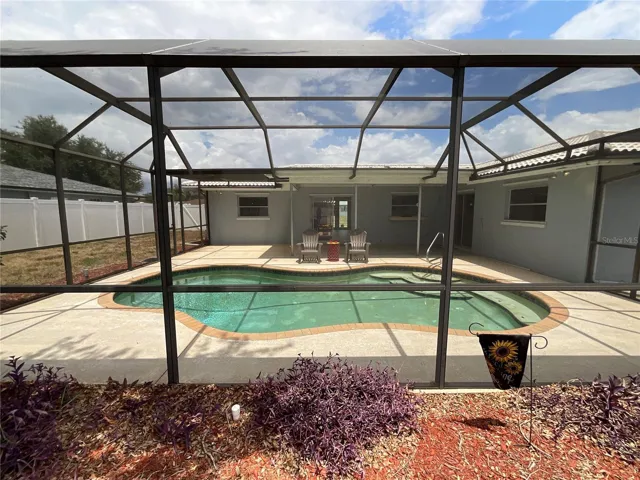 Quaint garden area beyond the screened pool cage