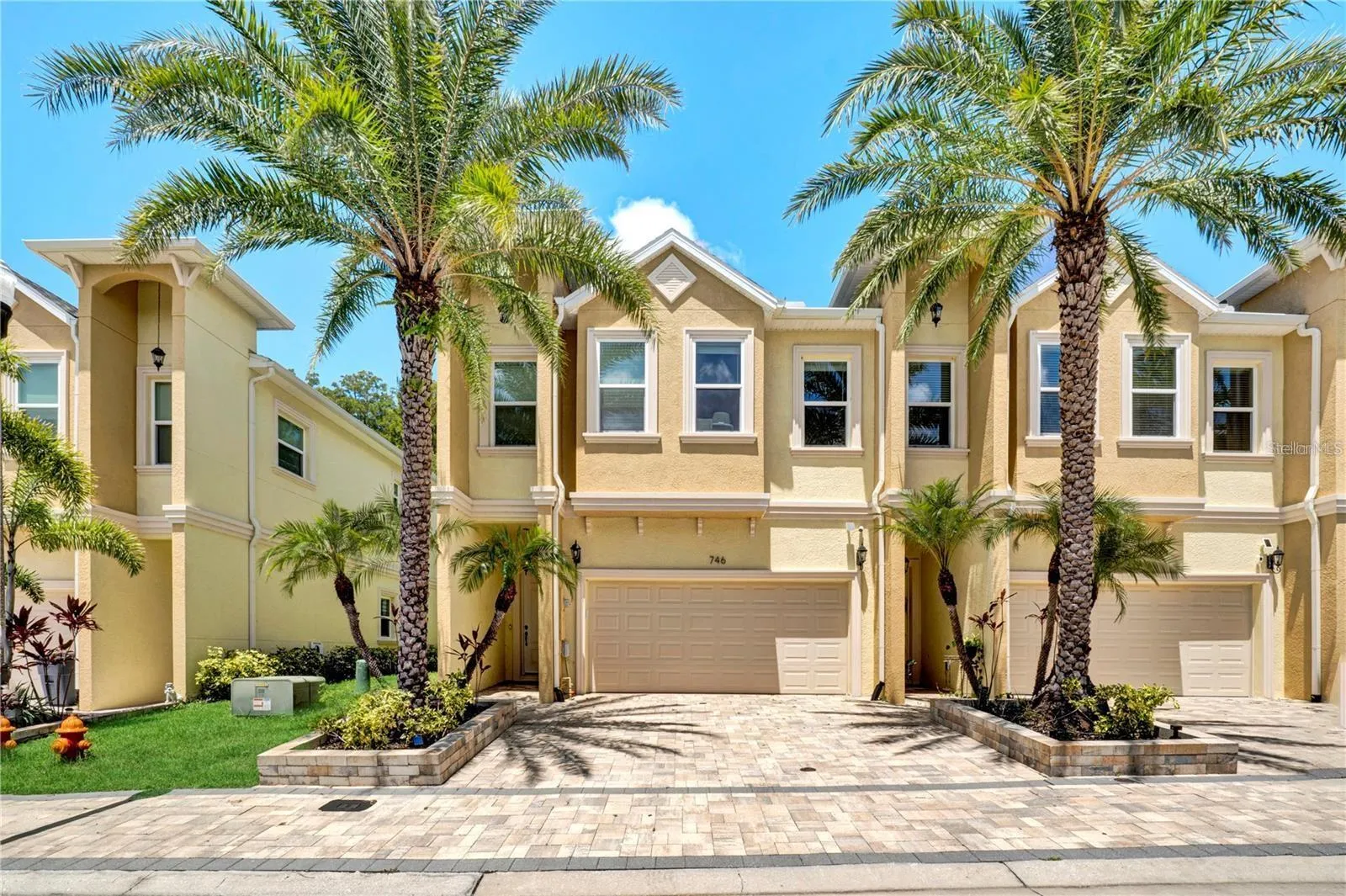 Welcome home! This stunning, modern townhouse boasts exceptional curb appeal with a paved driveway, a spacious two-car garage, and beautiful tropical palm landscaping
