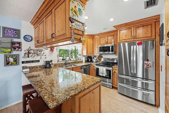 The kitchen features solid wood cabinets, granite countertops and newer appliances. It opens seamlessly to the dining and living room