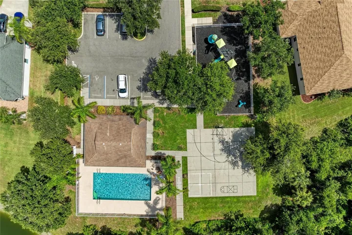 Aerial view of community pool, playground, basketball court.