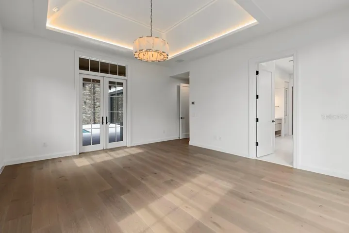 Luxurious primary bedroom with access to outdoor courtyard