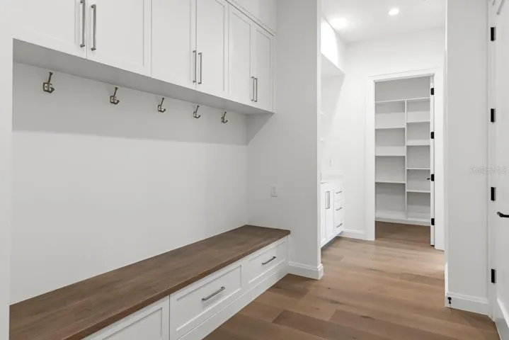 Drop zone area with custom wood cabinetry and shelving