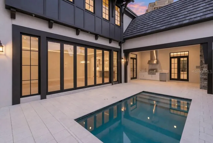Outdoor living area with summer kitchen and heated lounging pool