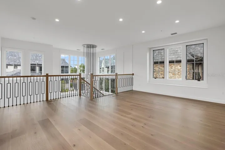Second-floor loft space adjacent to grand, winding staircaseopens to floor below