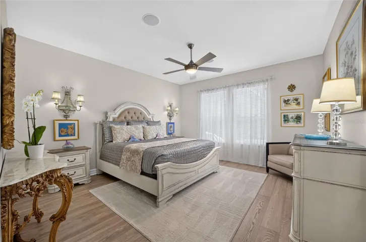 Primary bedroom with new luxury vinyl plank flooring, newer ceiling fan, huge walk in closet and ensuite to the primary bath.