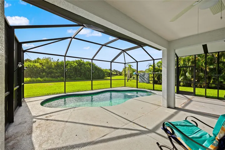 large covered lanai with view over pool to green space