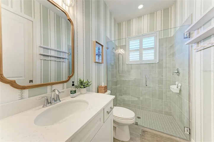 Guest bath with custom wallpaper and newly added glass doors