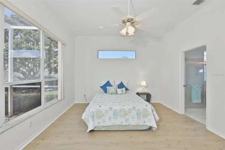 Large Primary Bedroom w/ Ensuite Bath, Plenty of Light, Newer LVT Flooring & View of the Pool & Wonderful Outdoor Living Space