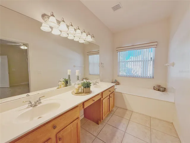 Primary Bathroom with garden tub, dual sinks, vanity space, separate shower, water closet, ceramic tile flooring
