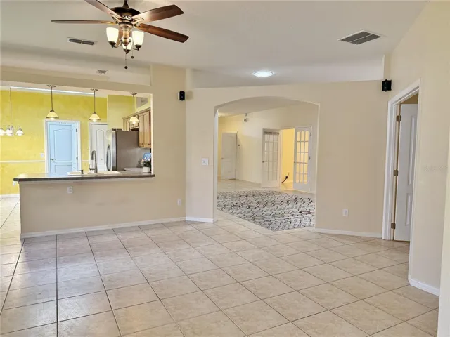 Family room with view of Kitcjen, Master bedroom on right and Living and Dining room in Background, light tube in ceiling, recessed lighting, ceramic tile flooring, open floor plan