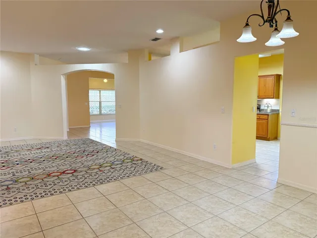View from Entry of Living room, walk through to the Kitchen and Family room and Florida room in background, recessed lighting, solar light tube, decorative shelf