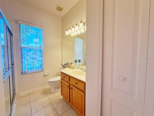 Bathroom 2 with ceramic tile flooring, linen closet, tub/shower combo with glass door