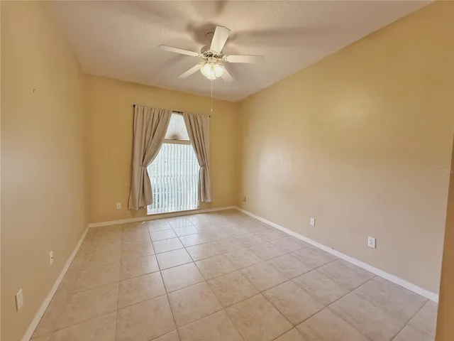 Bedroom 2 with ceramic tile flooring, decorative shelf, walk in closet