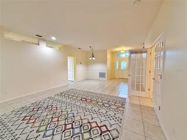 Living and Dining room with view of Kitchen on Left, Den/Study/ Bedroom 3 on right and view of Front entry