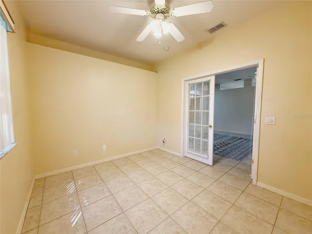 Den/study/Bedroom 3 with ceramic tile flooring, decorative shelf, double French door entry
