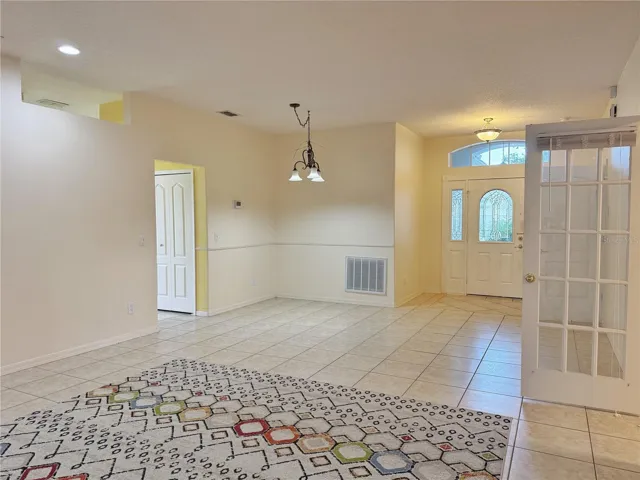 Dining nd Living room with French doors into the Den/study/bedroom 3, ceramic tile flooring, recessed lighting, beveled glass front door