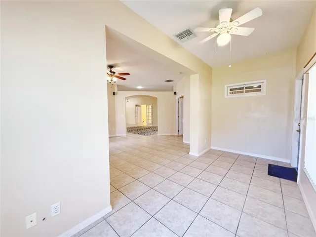 Florida room with view of the Family room and Living room beyond, ceramic tile flooring, opens to the screened in lanai