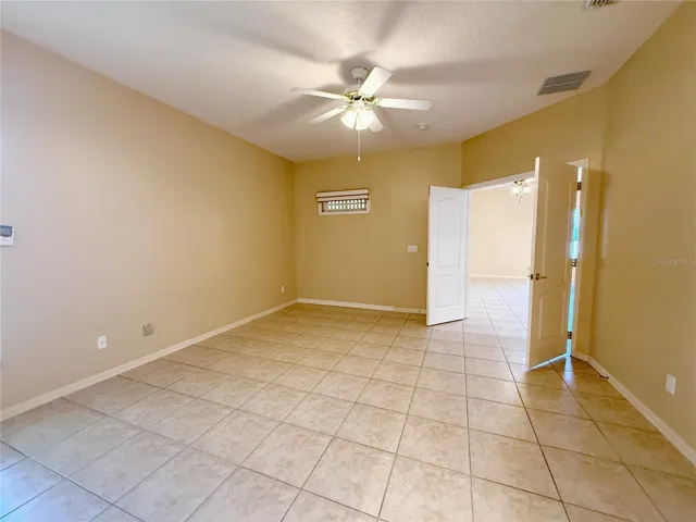 Primary Bedroom with double door entry, ceramic tile flooring, en suite bathroom, walk in closet