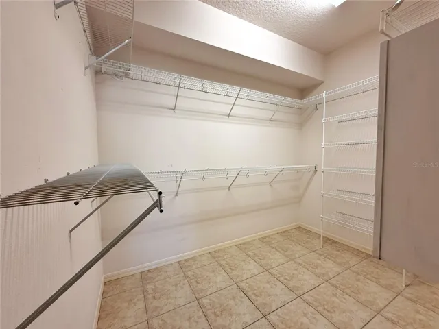 Primary walk in closet, ceramic tile flooring