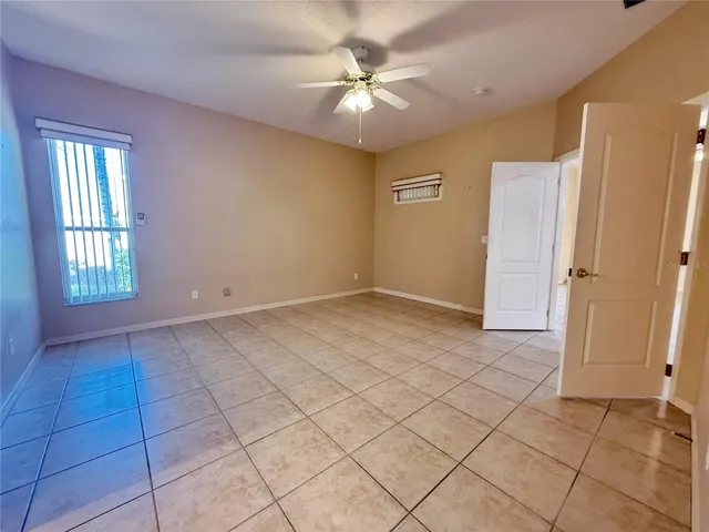 Additional view of the Primary Bedroom with ceramic tile flooring, walk in closet, en suite bathroom, double door entry