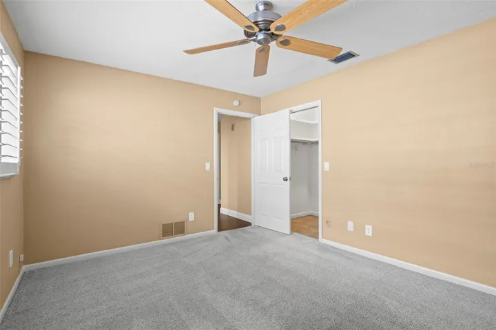 Bedroom 3 - ceiling fan, walk-in closet, and plantation shutters