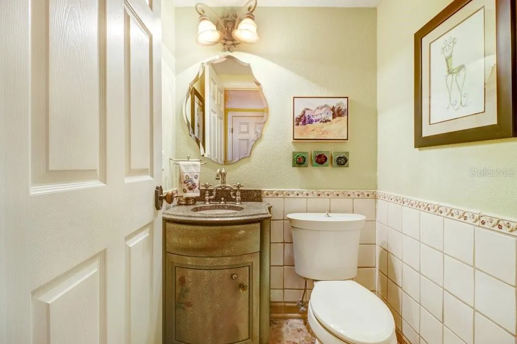 Charming custom 1/2 bath off kitchen with river rock floor tile.