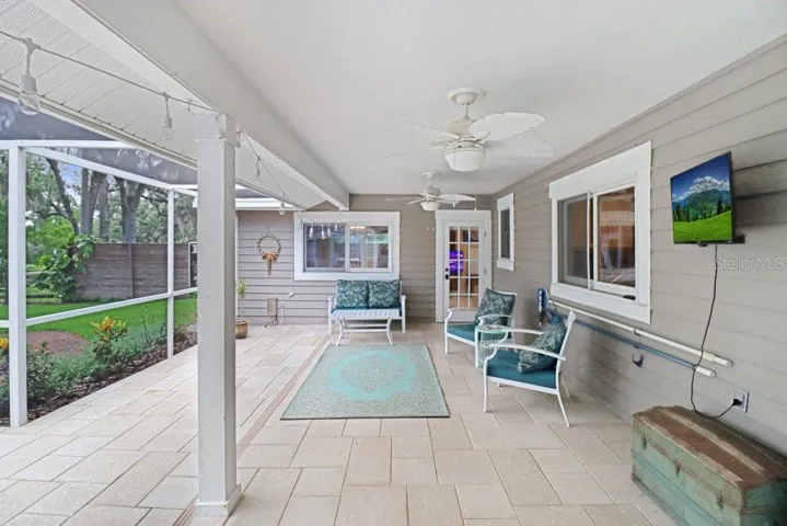 Relaxing patio area under roof with ceiling fans, perfect for parties and barbeques.