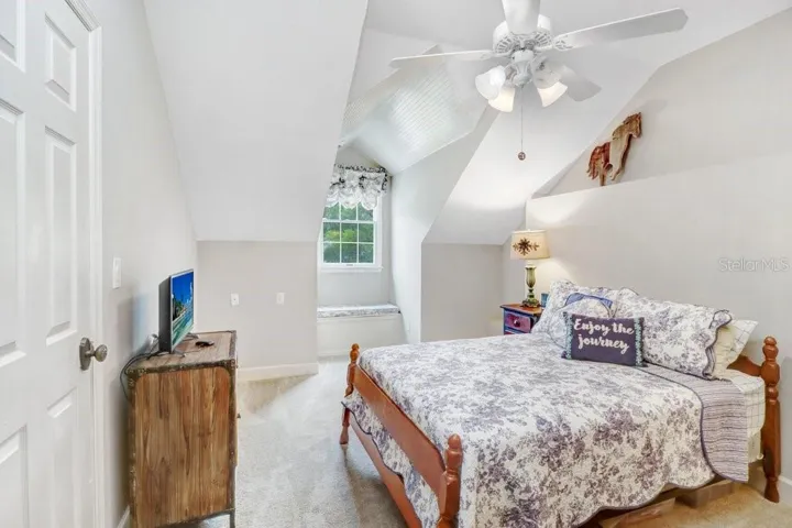 Large oversized guest room with window seat that has storage and walk in closet with vaulted ceilings.
