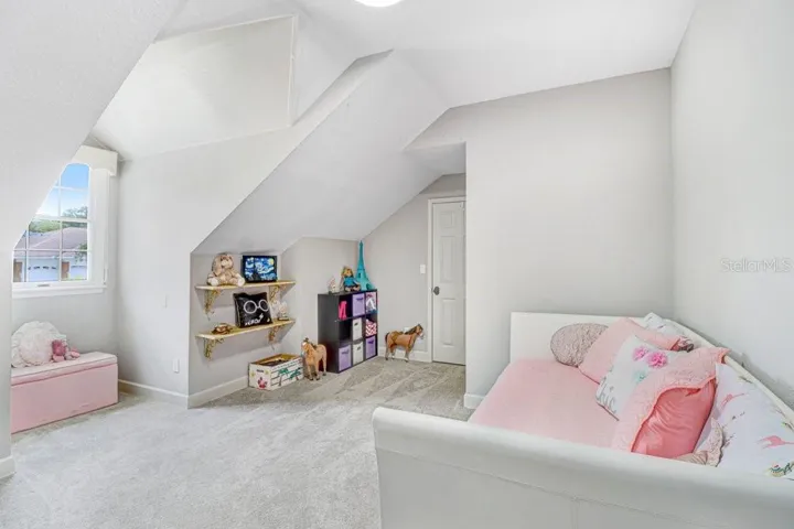 Another view of bedroom with plenty of space and cool angled ceilings.