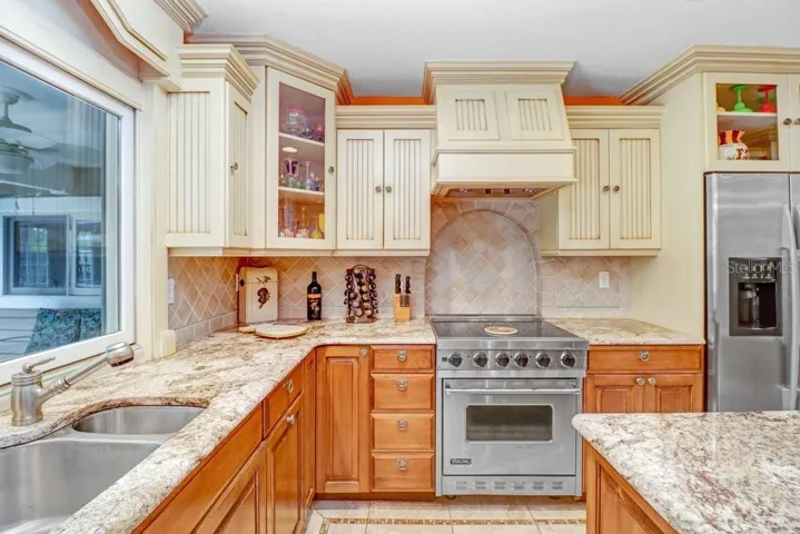 Viking Range and split stainless steel sink and decorative tile backsplash.