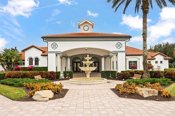 Watersong Resort clubhouse featuring elegant Mediterranean-inspired architecture, a grand covered entrance, and a decorative fountain.