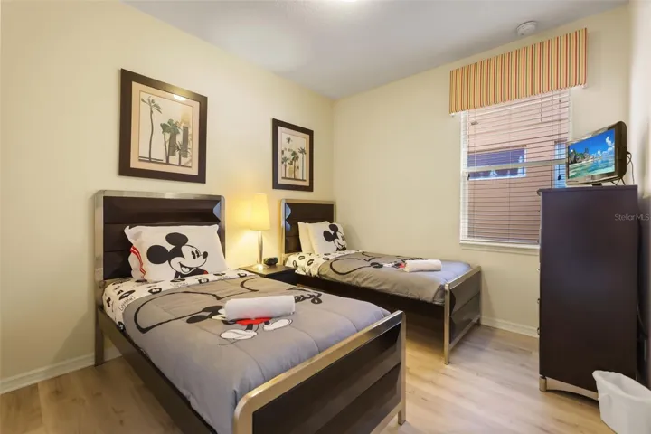 Bright guest bedroom with twin beds, tasteful décor, and plenty of natural light.