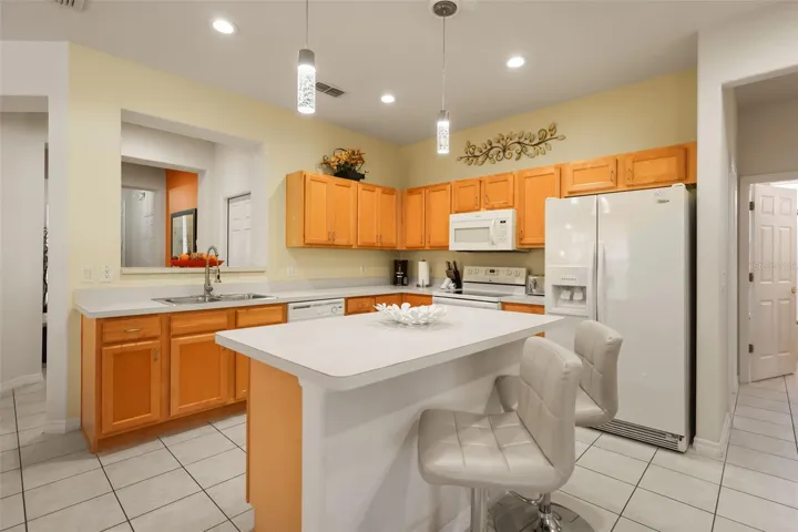 Spacious kitchen featuring ample cabinetry, generous countertop space, breakfast bar seating, and a center island.