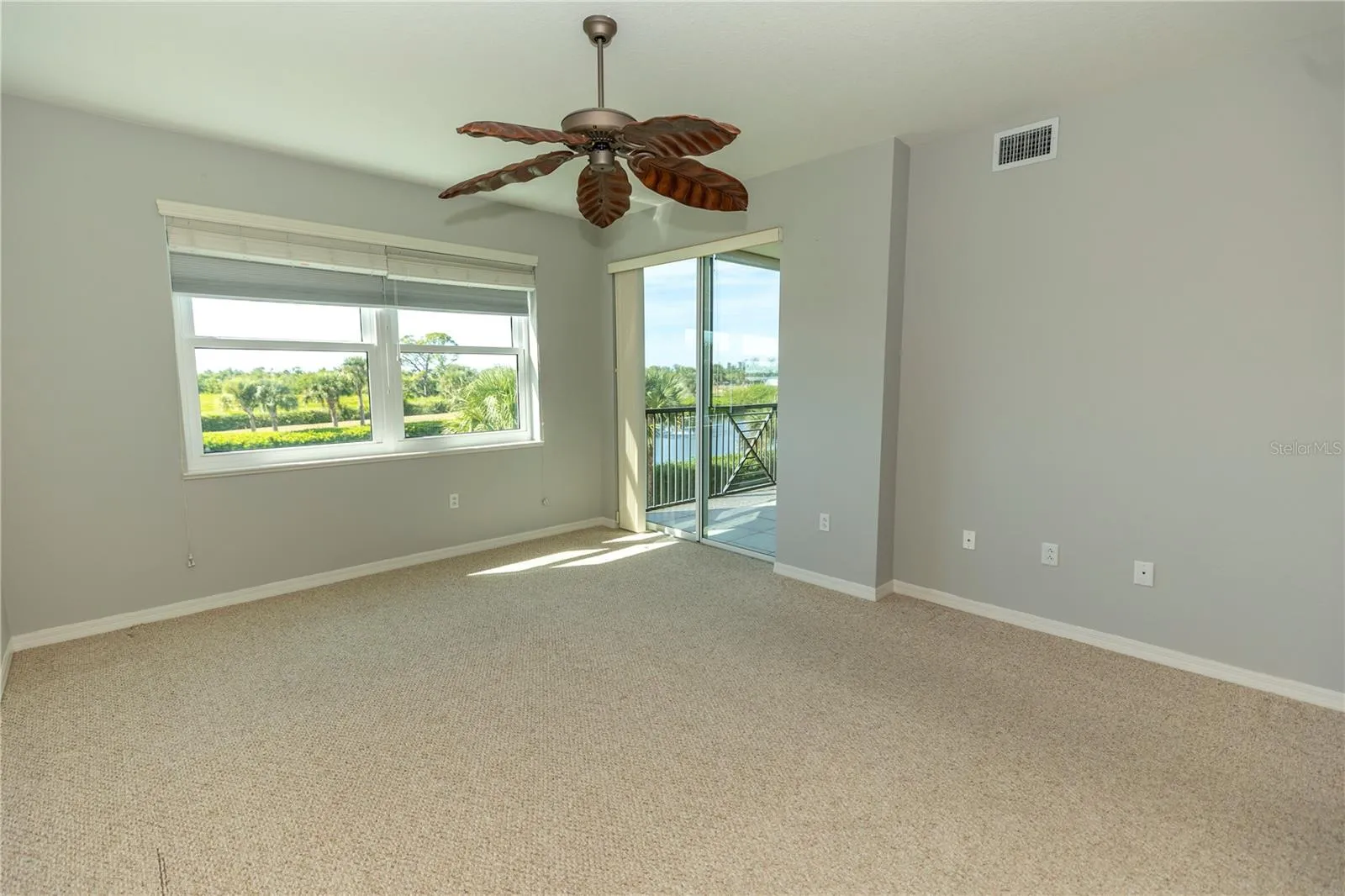 Primary bedroom with slider to lanai and hurricane shutters