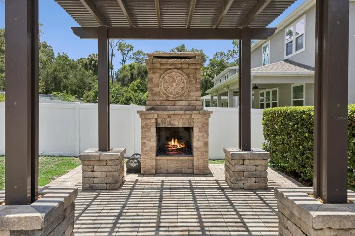 Wood-burning fireplace & pergola in the back yard