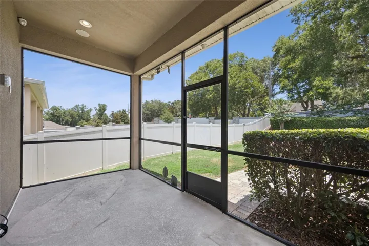 Rear screened porch offers access to the fenced, lush backyard
