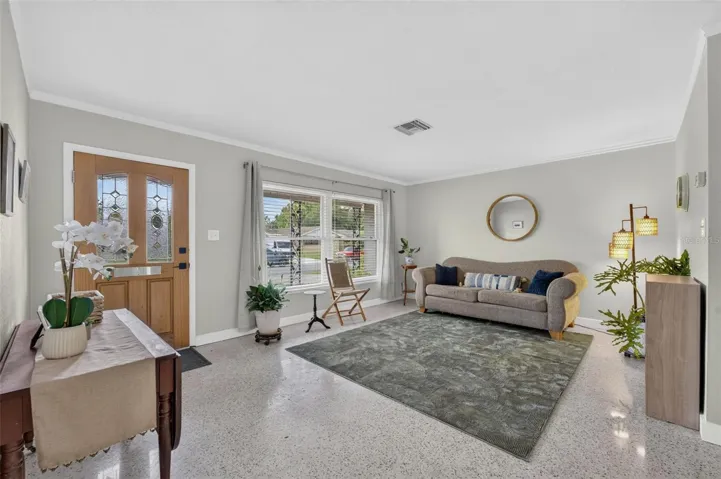 Living space with terrazzo flooring and crown molding